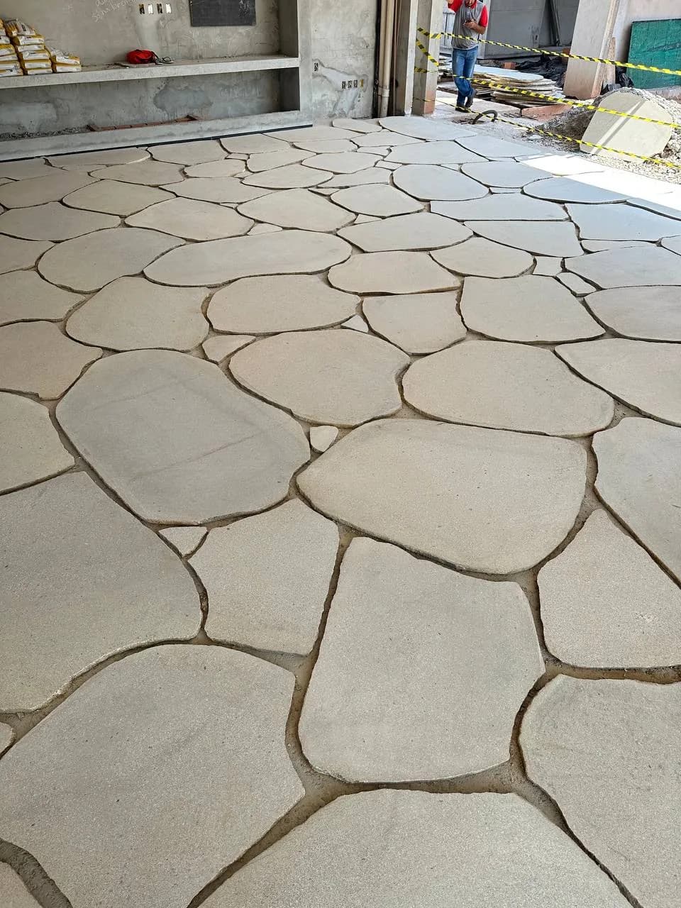 Placas naturais em formato orgânico, atérmicas e antiderrapantes. O piso que conecta a casa ao jardim.